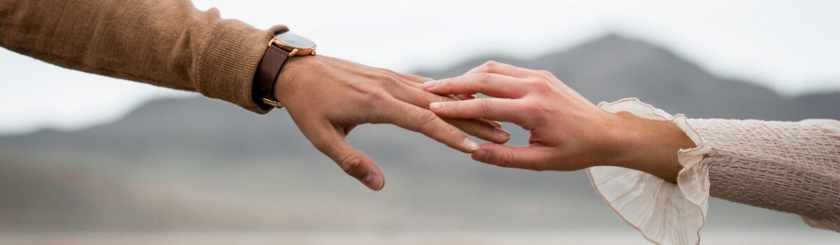 Jeweils eine Hand von Mann und Frau berühren sich an den Fingerspitzen.