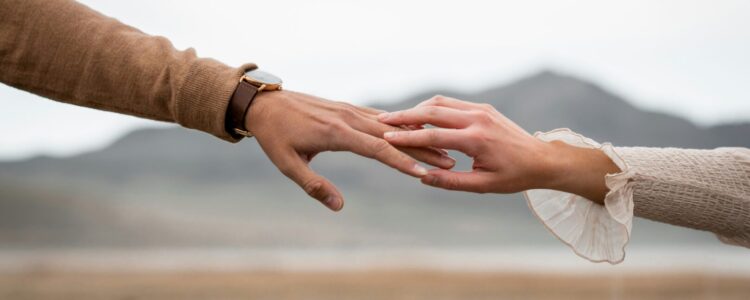 Jeweils eine Hand von Mann und Frau berühren sich an den Fingerspitzen.